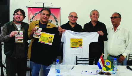Jornalista Leonardo Severo, senadores Hugo Richer e López Perito, Antonio Lisboa (CUT) e Bernardo Rojas (CUT-A) com a camiseta em solidariedade aos presos políticos e o livro Curuguaty, carnificina para um golpe
