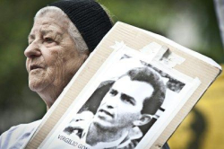 Ilda segura cartaz com a foto do marido, o militante VirgÃ­lio Gomes da Silva, uma das vÃ­timas do capitÃ£o