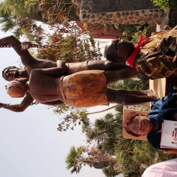 JÃºlia com a cartilha da CUT aos pÃ©s do monumento Ã  libertaÃ§Ã£o dos escravos, em GorÃ©e,